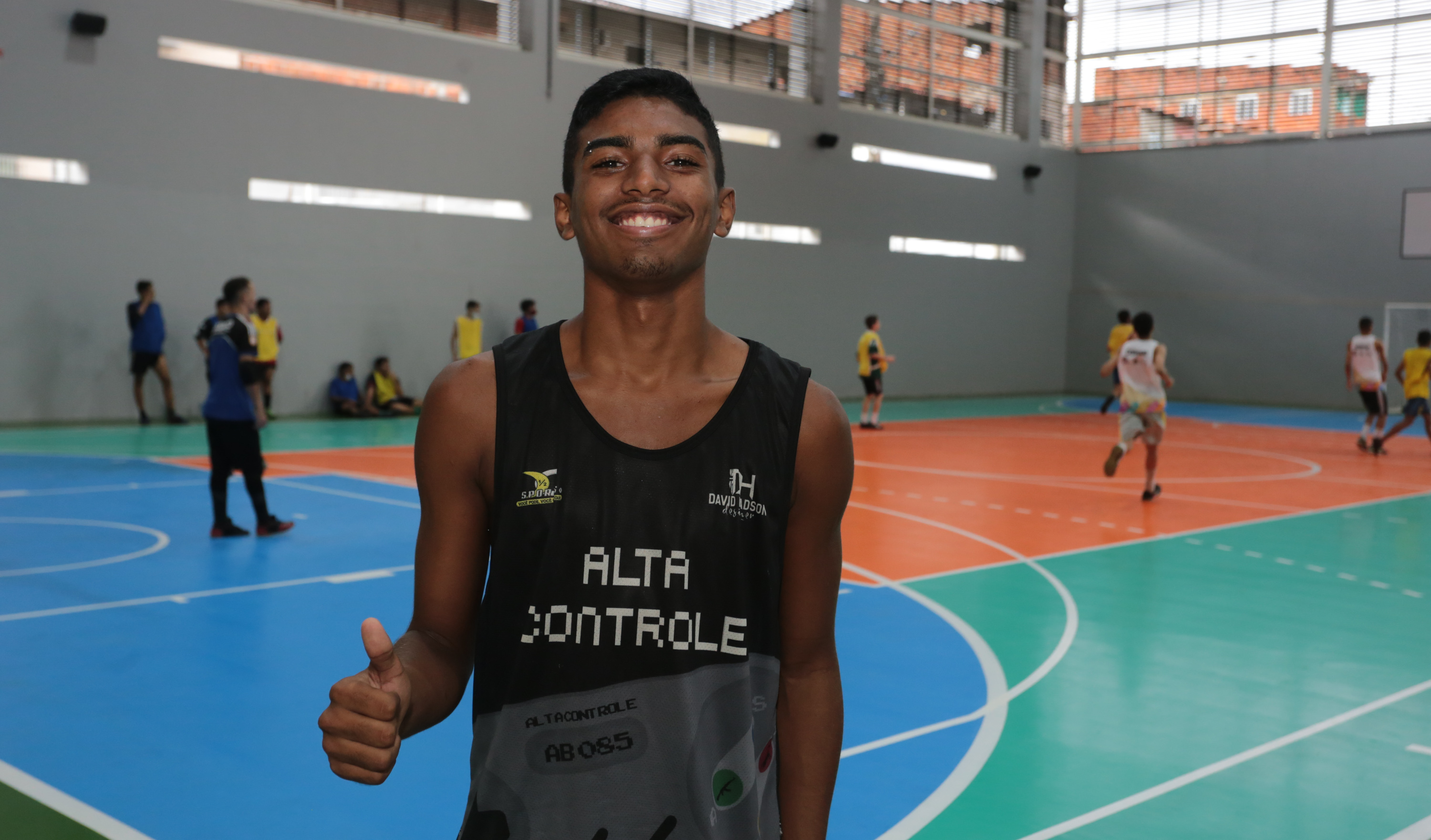 jovem posa para a foto em uma quadra de futsal